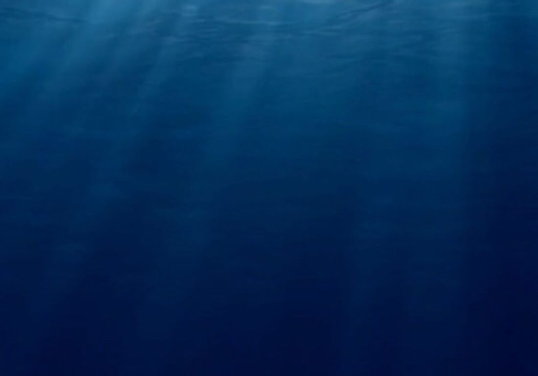 Sunlight beams penetrating deep blue ocean water.