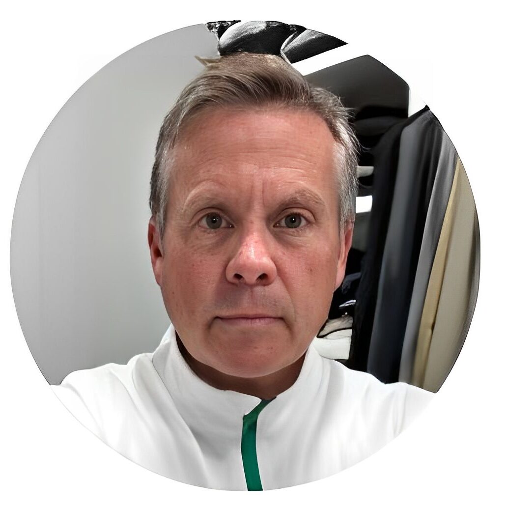 Portrait of a middle-aged man with short hair in a white jacket.